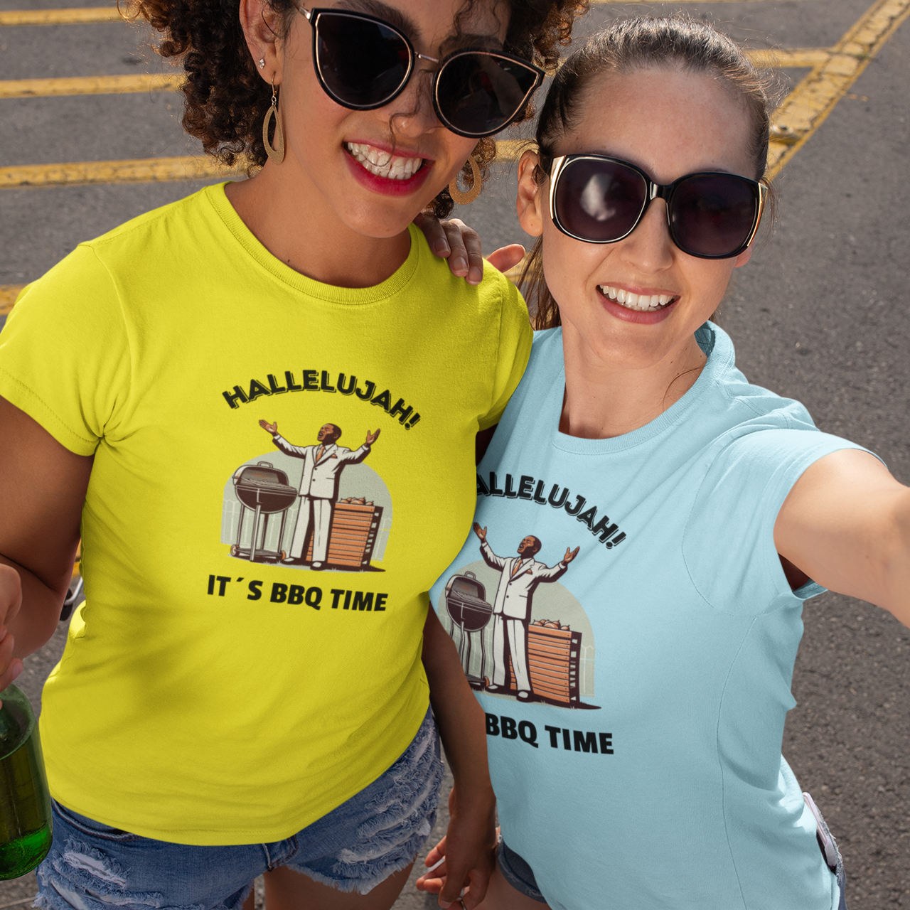 Two women wearing t-shirts with a barbecue-themed design, standing in a parking lot.